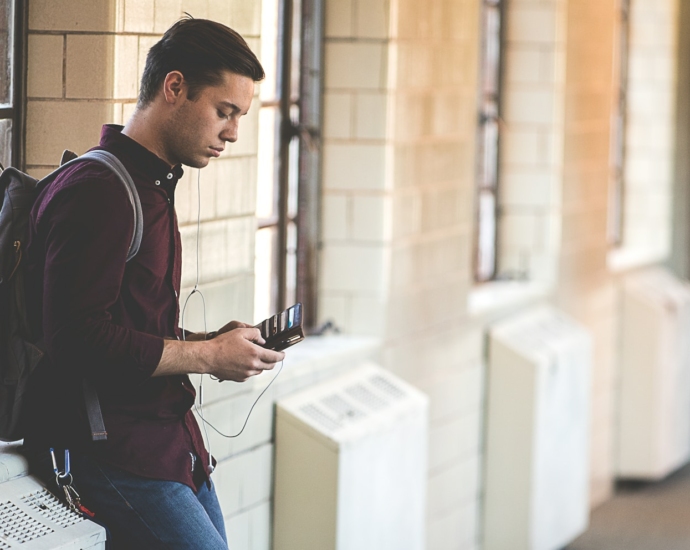 man leaning while holding leather wallet