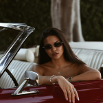 a woman sitting in the back of a red car