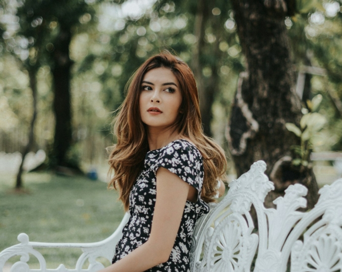 woman sitting on white bench outdoors