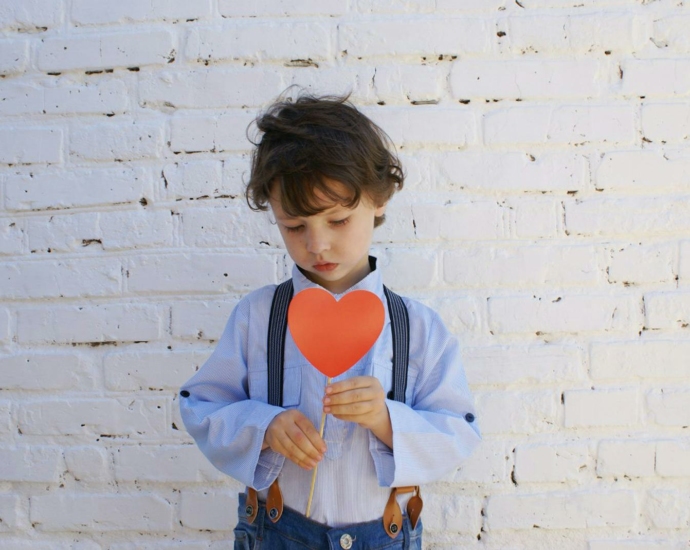 Photo of Boy Holding Heart-shape Paper on Stick