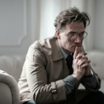 Man in Brown Suit Jacket Sitting on White Sofa