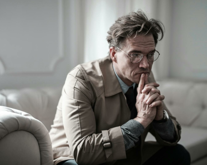 Man in Brown Suit Jacket Sitting on White Sofa