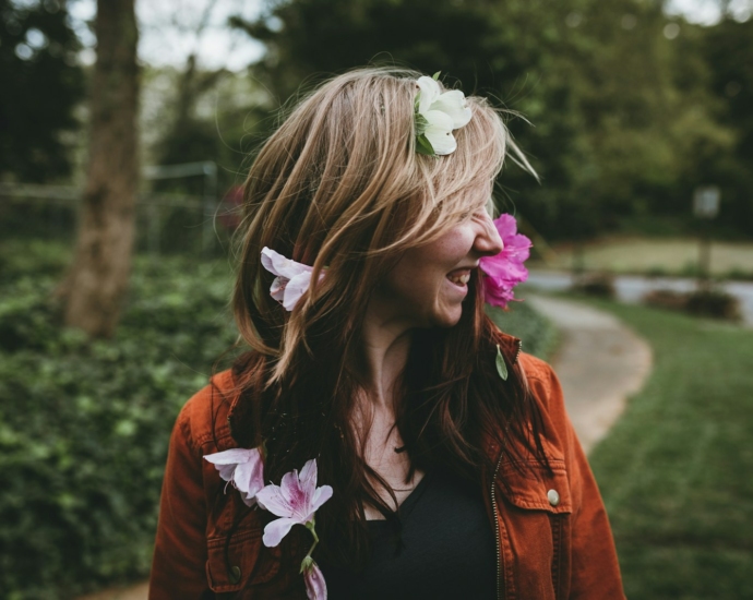 smiling woman standing near trees during daytime