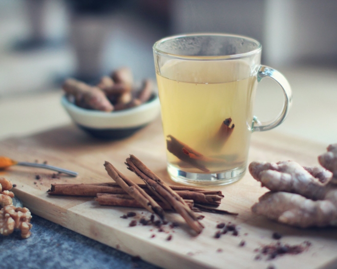 clear glass mug with yellow liquid on brown wooden chopping board