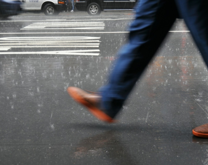 man wearing blue pants walking on street