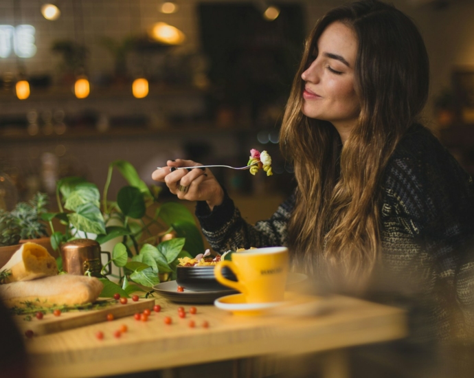 woman holding fork in front table