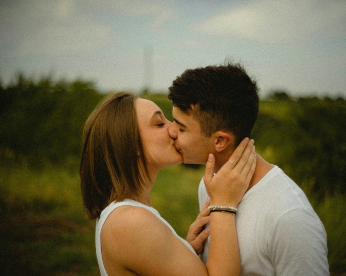 man in white tank top kissing woman in white tank top