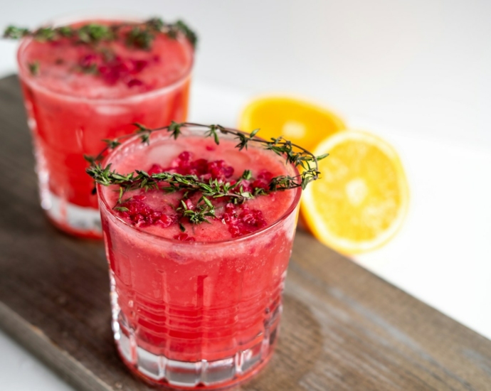 clear drinking glass with red liquid and sliced lemon