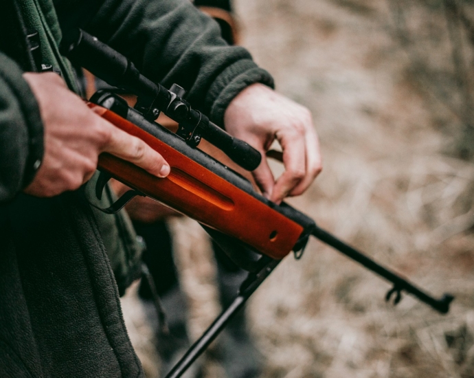 person loading brown and black sniper rifle