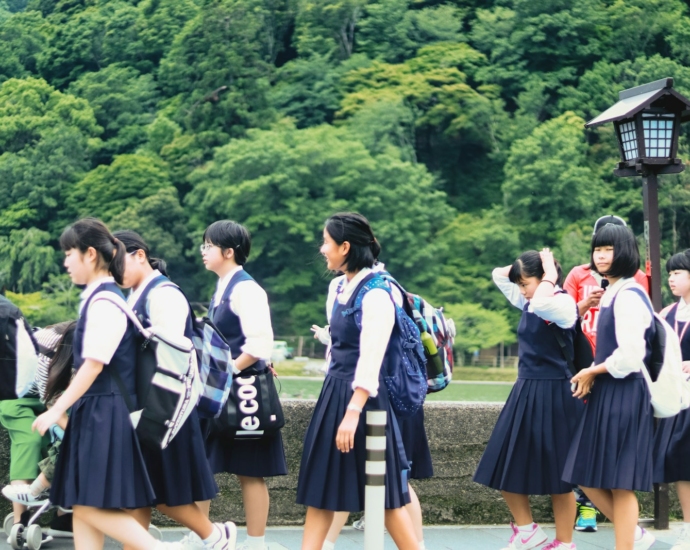 group of women in school uniform standing on green grass field during daytime