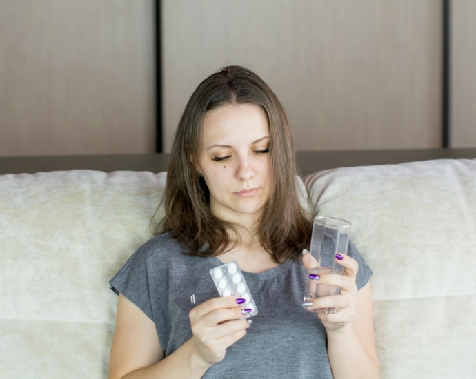 a woman sitting on a couch looking at her cell phone