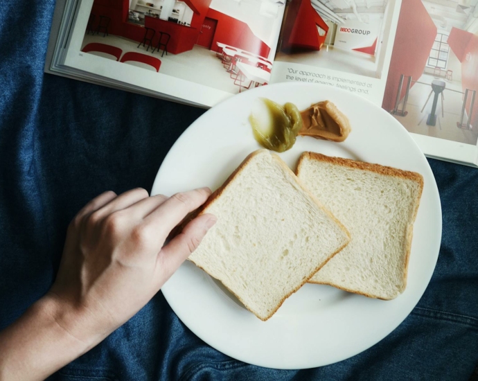 Person Touching the Bread on Plate