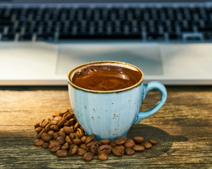 Close-Up Photo of Coffee Cup Beside Coffee Beans