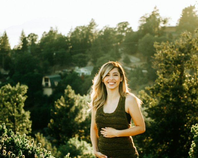 woman standing in front of trees during sunset