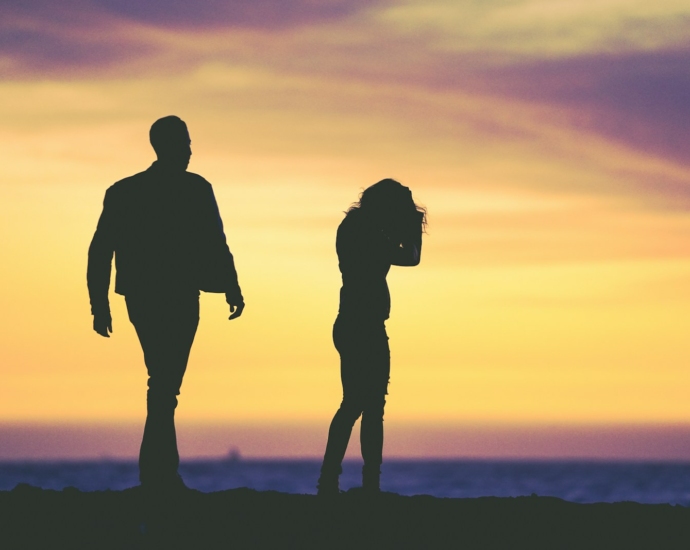 silhouette of man and woman under yellow sky