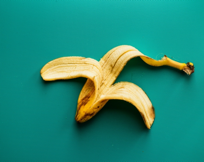 a peeled banana sitting on top of a green surface