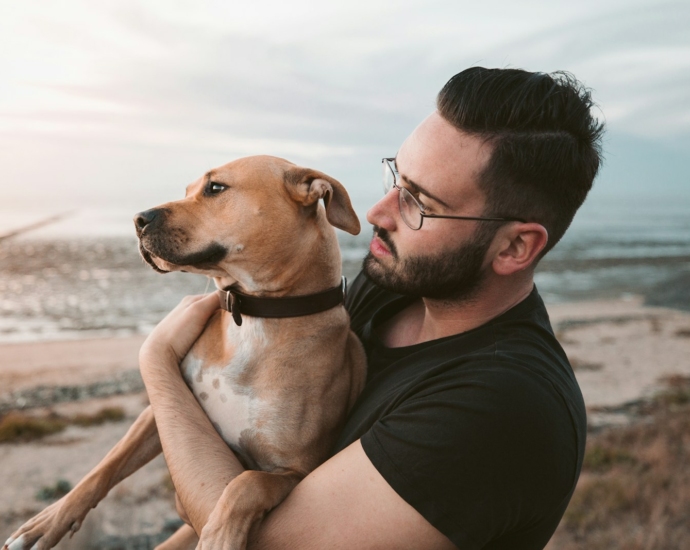 man holding a brown dog