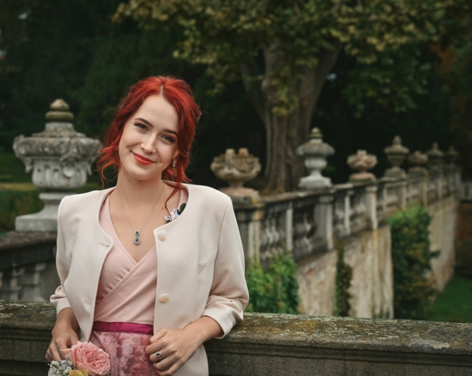 a woman with red hair is standing on a bridge