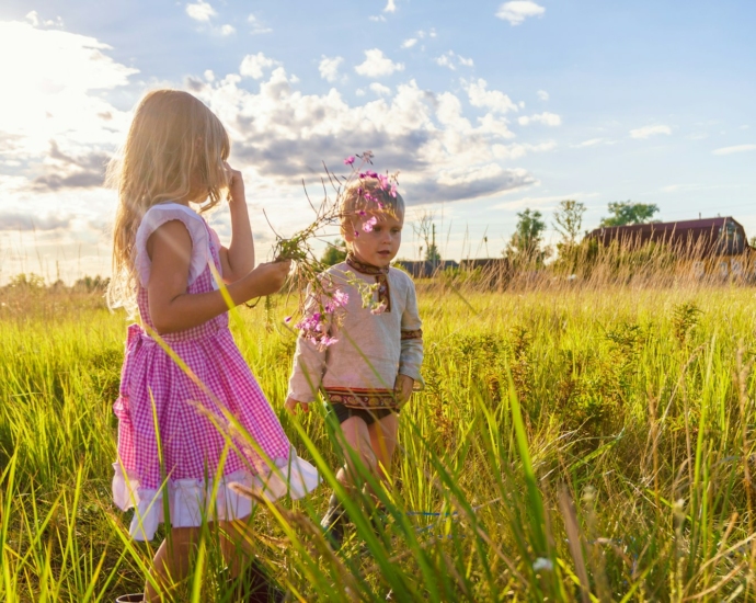 girl in pink and white dress standing on green grass field during daytime