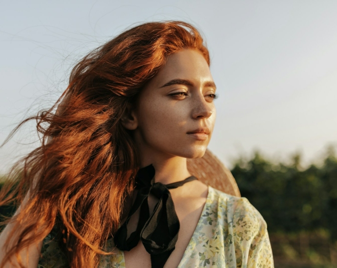 a woman with long red hair wearing a black tie