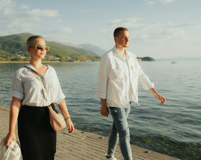 a man and a woman walking along a pier