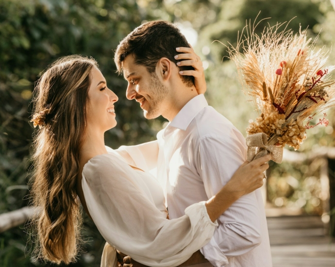 man in white dress shirt holding brown flower bouquet