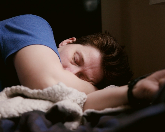 woman in blue shirt lying on bed