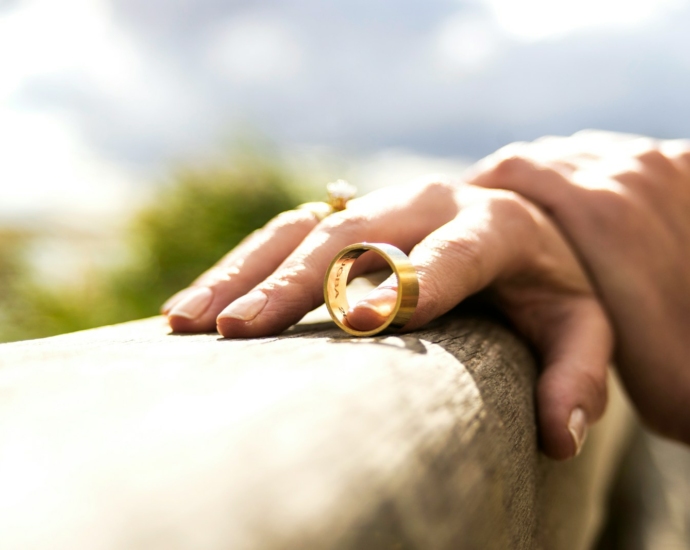 person holding gold wedding band