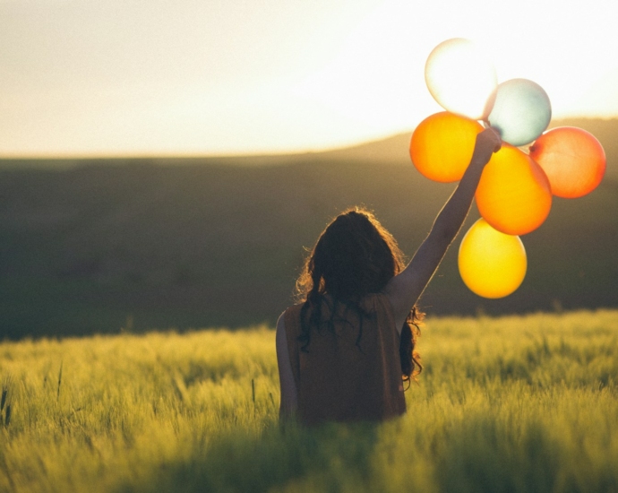 unknown person holding balloons outdoors