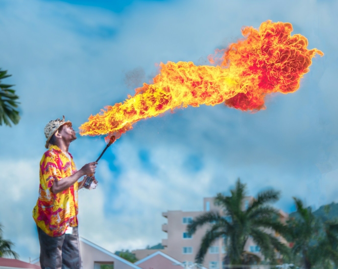 man blowing gas to make fire