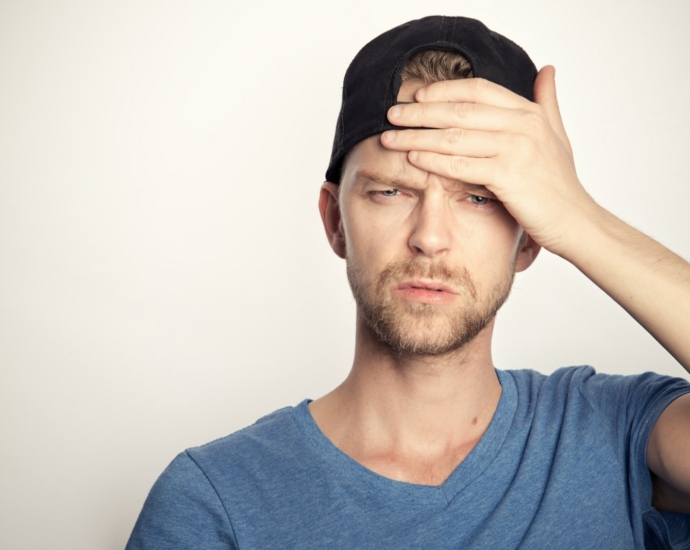 man in blue crew neck shirt covering his face