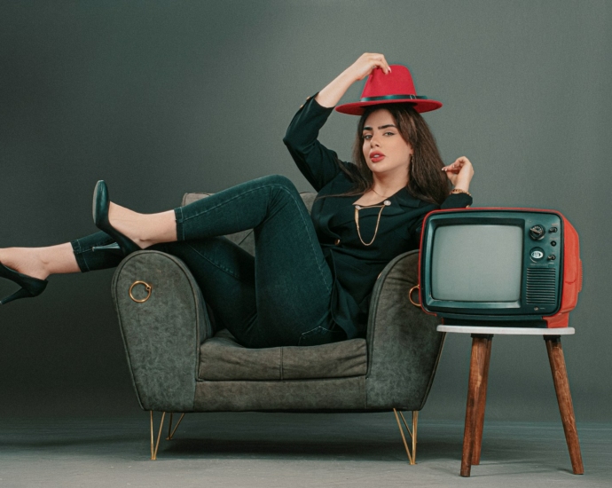 a woman sitting on a chair with a red hat on her head