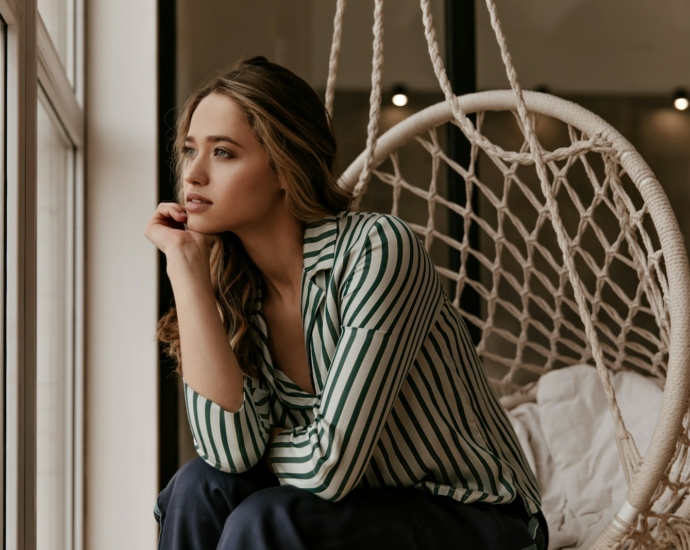 a woman sitting in a chair next to a window