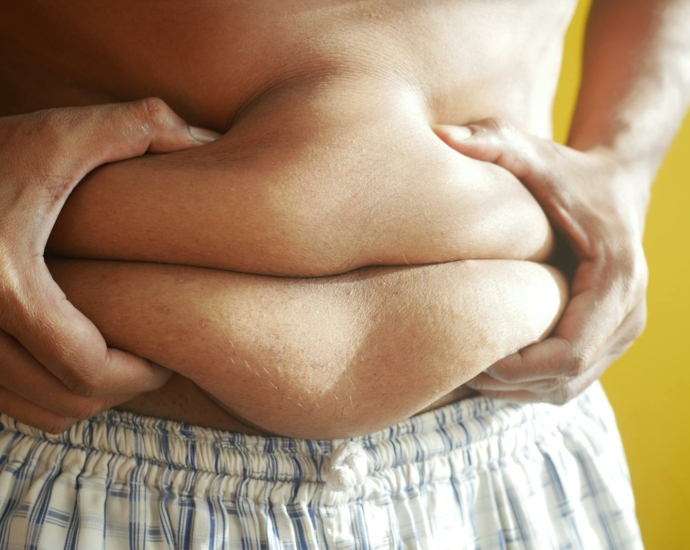 A Person Holding on to Belly Fat