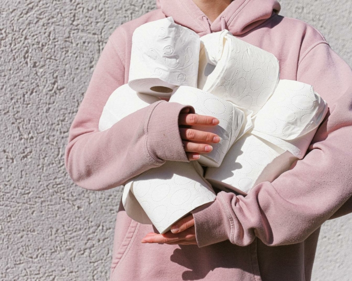 Woman in Pink Long Sleeve Hoodie Carrying Tissue Rolls