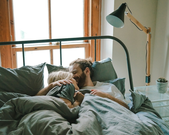 man kissing woman on her forehead