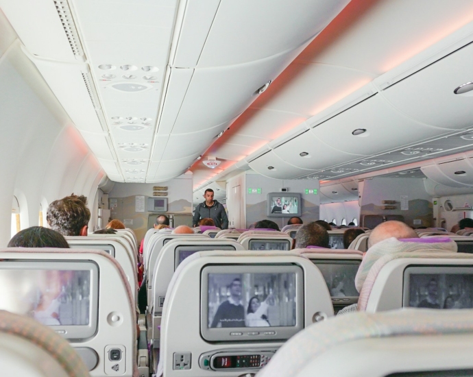 man walking down the aisle of airplane