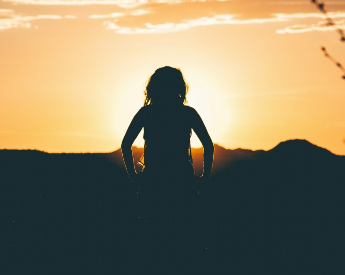 silhouette of person looking at sunset