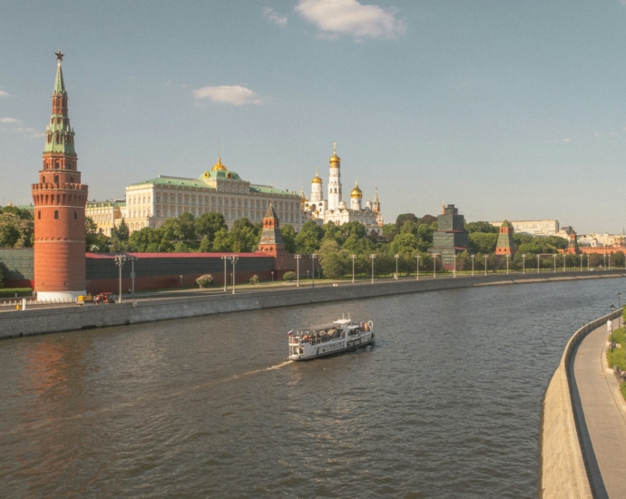 a boat traveling down a river next to tall buildings