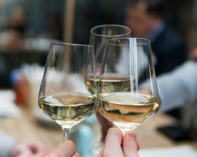 three people having a toast using three clear crystal wine glasses