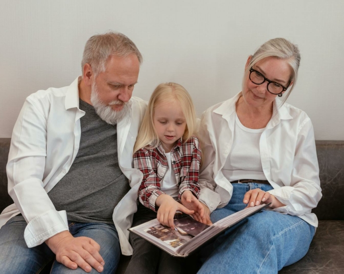 Grandparents Sitting on Leather Sofa with their Grandchild