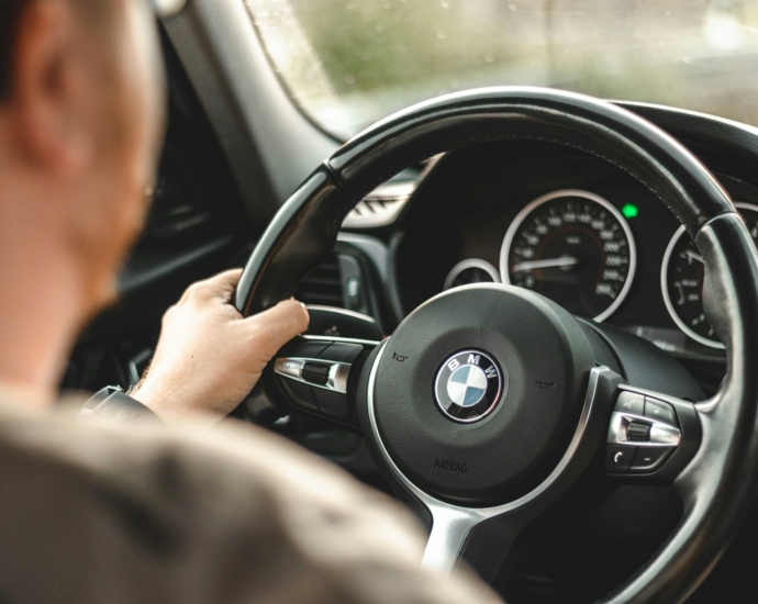 person driving bmw car during daytime