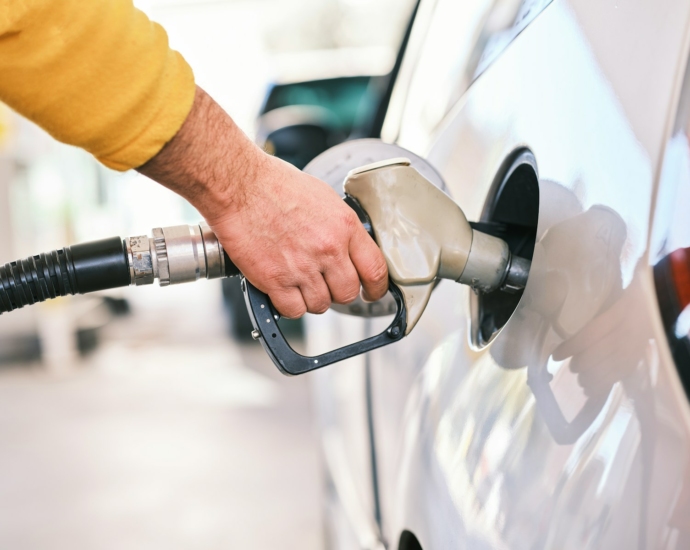 a man pumping gas into his car at a gas station