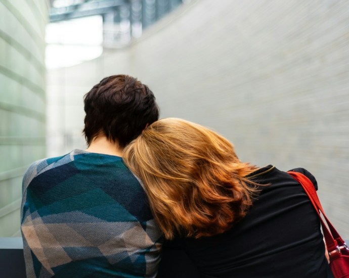 a woman rests her head on another person's shoulder