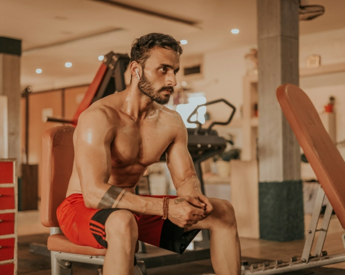 a man sitting on a bench in a gym