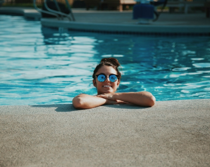 woman wearing sunglasses on swimming pool during daytime