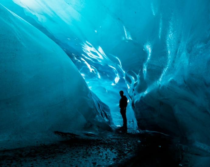 person standing in ice cave at daytime