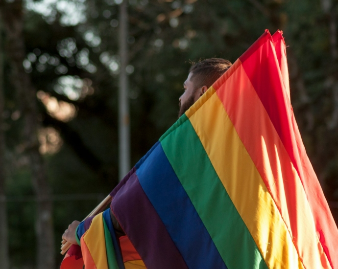 a man holding a rainbow flag in his hands