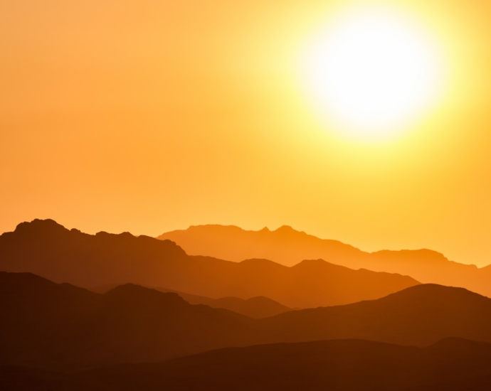 silhouette of mountains under orange sky