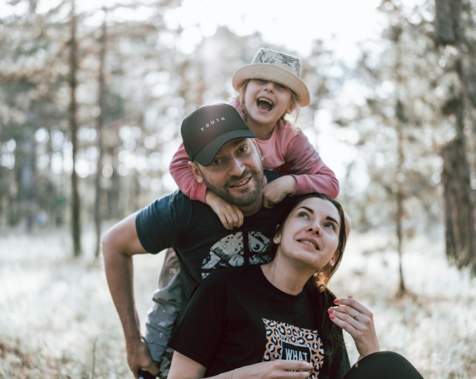 a man holding a little girl on his shoulders